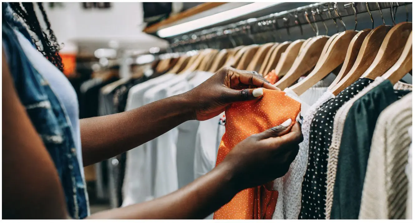 Image of a woman looking through a rack of clothes